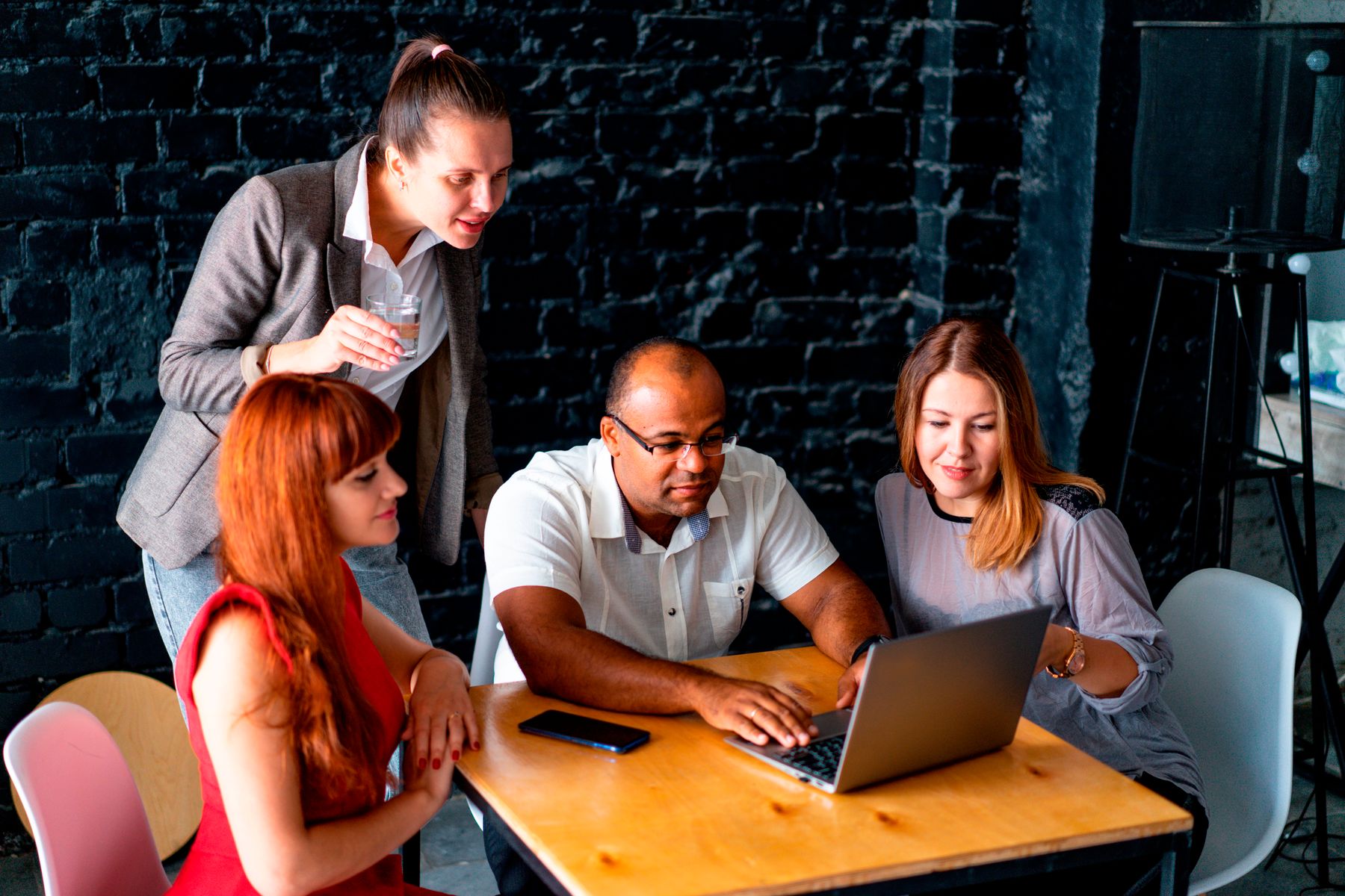 The Xashy team collaborating around a table with laptops